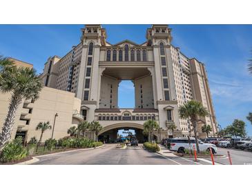 View of the building exterior showing elegant architecture, grand entrance, and lush tropical landscaping at 100 North Beach Blvd. # 710, North Myrtle Beach, SC 29582