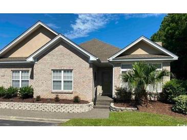 Charming brick home featuring well-maintained landscaping and mature trees at 1428 Saint Thomas Circle # B-1, Myrtle Beach, SC 29577