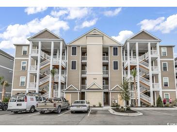 Three-story condo building featuring a beige exterior and white pillars, with parking available in front at 149 Ella Kinley Circle # 302, Myrtle Beach, SC 29588