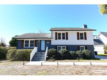 Charming two-story home with light blue door, white trim, and well-manicured landscaping at 1931 Lakeview Circle, Surfside Beach, SC 29575