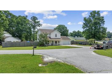 Charming two-story home featuring a well-manicured lawn, attached garage, and a welcoming covered front porch at 216 Deer Trace Circle, Myrtle Beach, SC 29588