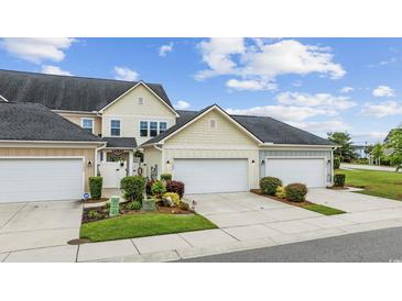 Charming townhome with attached garage and landscaped front yard on a sunny day at 2504 Heritage Loop # 2504, Myrtle Beach, SC 29577