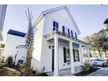 Charming two-story home featuring a covered porch, white siding, and lush landscaping at 3547 Ladybank Loop, Myrtle Beach, SC 29577