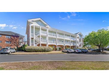 Inviting condo building featuring stairways and a parking lot with landscaping at 3935 Gladiola Ct. # 302, Myrtle Beach, SC 29588
