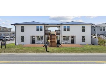 Charming two-story home featuring a shared staircase, front decks, and a well-maintained lawn at 4501 N Ocean Blvd., North Myrtle Beach, SC 29582