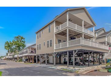 Coastal home on stilts, boasting multiple balconies, covered parking, and beachy charm against a clear blue sky at 6001- 8005 S Kings Hwy., Myrtle Beach, SC 29575