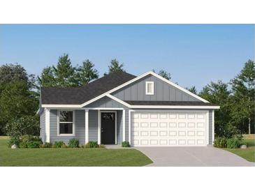 Charming single-story home featuring a gray exterior, manicured lawn, and attached two-car garage at 6366 Swainson Street Sw, Ocean Isle Beach, NC 28469