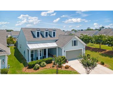 Charming home featuring dormer windows, a covered porch, and a two-car garage, set amidst a well-manicured lawn at 6378 Torino Lane, Myrtle Beach, SC 29572