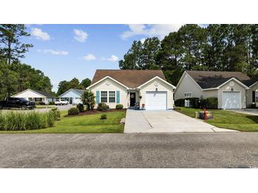 Charming single-story home with a well-manicured lawn, attached garage, and inviting curb appeal at 6681 Wisteria Dr., Myrtle Beach, SC 29588