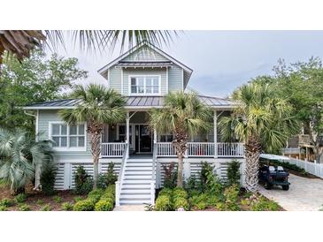 Charming two-story coastal home featuring a welcoming front porch, lush landscaping, and a convenient golf cart at 70 Beachwalker Ct., Georgetown, SC 29440