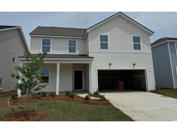 Charming two-story home with white siding, manicured lawn, attached garage, and a welcoming front porch at 1050 Laconic Dr., Myrtle Beach, SC 29588
