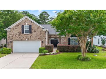 Charming brick home featuring a well-manicured lawn, double-door entrance, and attached two-car garage at 106 Cypress Creek Dr., Murrells Inlet, SC 29576
