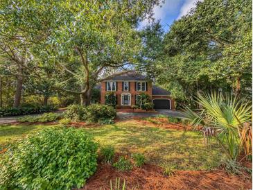 Beautiful brick home with mature trees and a manicured lawn in a serene setting at 1073 Crooked Oak Dr., Pawleys Island, SC 29585