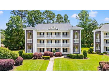 Three story condo building with multiple balconies, brick accents, manicured lawn and shrubs at 1208 River Oaks Dr. # 24-B, Myrtle Beach, SC 29579