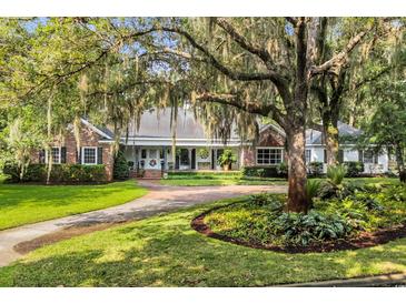 Stunning brick home with mature trees and a circular driveway provides great curb appeal at 1259 Oatland Lake Rd., Pawleys Island, SC 29585