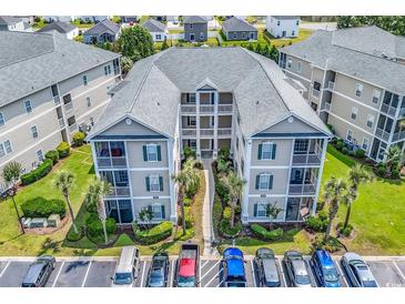 Aerial view of condominiums with multiple stories, balconies, convenient parking, and lush landscaping at 2020 Cross Gate Blvd. # 203, Surfside Beach, SC 29575