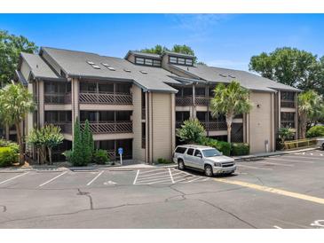 Multi-story condo building with balconies, parking, and landscaping on a bright, sunny day at 223 Maison Dr. # B-8, Myrtle Beach, SC 29572