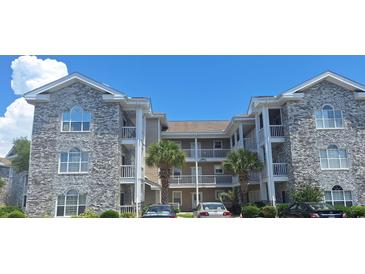 Multi-level condo building featuring charming architecture, balconies, and well-maintained landscaping at 4753 Wild Iris Dr. # 301, Myrtle Beach, SC 29577
