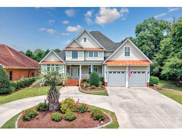 Charming two-story home with a well-manicured lawn, a two-car garage, and a welcoming front porch at 504 Sea Vista Ln., North Myrtle Beach, SC 29582