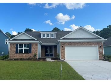 Charming single-story home with stone accents, white garage door, and a well-manicured lawn at 7180 Shooting Star Way, Myrtle Beach, SC 29579