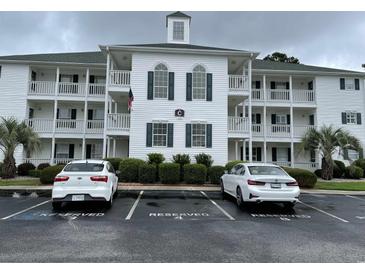 Three-story condominium building featuring reserved parking, manicured landscaping, and classic architectural details at 770 Charter Dr. # C4, Longs, SC 29568