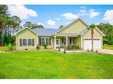 Charming single-story home with a lush green lawn, tidy landscaping, and a welcoming front porch at 1013 Happy Ln., Galivants Ferry, SC 29544