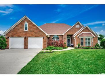 Charming brick home with a well-manicured lawn and attached two-car garage at 1017 Coral Reef Dr., North Myrtle Beach, SC 29582