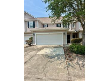 Tan two-story townhome with an attached two-car garage and a concrete driveway at 1048 Fairway Ln. # 1048, Conway, SC 29526