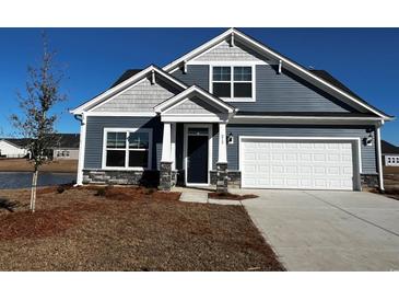 Charming single-Gathering home featuring a well-manicured lawn and an attached two-car garage at 1087 Laconic Dr., Myrtle Beach, SC 29588