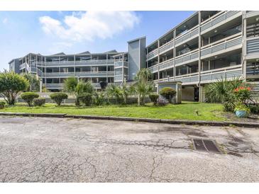 This building has multi-level balconies, a grassy area with shrubs, and plenty of parking for all its tenants at 1101 Possum Trot Rd. # D201, North Myrtle Beach, SC 29582