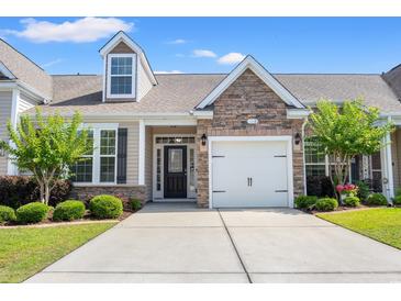 Charming home featuring a stone-accented facade, attached garage, and well-maintained landscaping with green lawn at 121 Parmelee Dr. # D, Murrells Inlet, SC 29576
