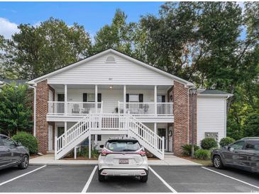 Charming condo featuring white siding, brick accents, and inviting double porches at 157 Egret Run Ln. # 523, Pawleys Island, SC 29585