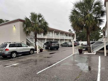 The condo building has white stairs, tropical landscaping, and parking at 2204 South Perrin Dr. # 29, North Myrtle Beach, SC 29582