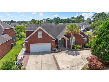 Charming single-story brick home featuring a palm tree in the landscaped front yard and an attached two-car garage at 2384 Covington Dr., Myrtle Beach, SC 29579