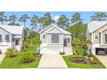 Charming coastal home featuring a two-car garage and well-manicured lawn at 277 Splendor Circle, Murrells Inlet, SC 29576