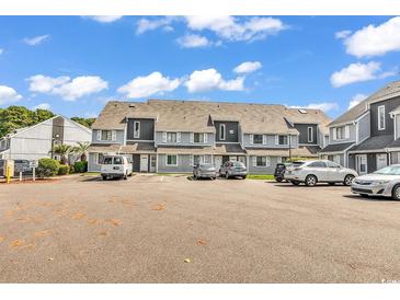 A townhouse complex featuring ample parking and exterior gray color scheme at 3700 Golf Colony Lane # 25G, Little River, SC 29566