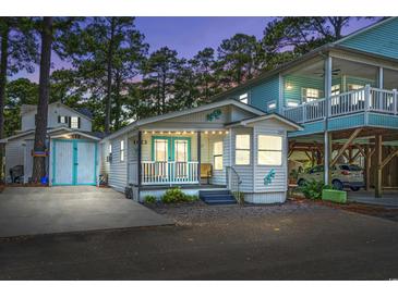 Charming beach home with a cozy front porch, white siding, and whimsical lizard accents at 6001-1623 S Kings Hwy., Myrtle Beach, SC 29575