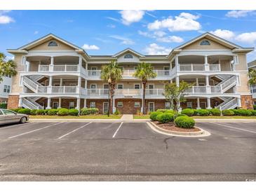Three story condo with white balconies, palm trees, and plenty of parking at 6015 Catalina Dr. # 733, North Myrtle Beach, SC 29582