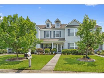 Charming two-story townhome with blue shutters, lush landscaping, and a well-manicured lawn at 816 Barn Owl Ct. # 816, Myrtle Beach, SC 29579
