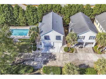 An aerial view of a stilt home in a community with a swimming pool and mature landscaping at 1125 Camellia Dr., Surfside Beach, SC 29575