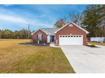 Charming single-story brick home featuring an attached two-car garage and well-maintained landscaping at 1200 Bergen Dr., Loris, SC 29569