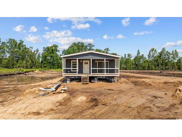 New construction home showing the front elevation with an inviting front porch and visible construction site surroundings at 1321 Rabbit Ln., Conway, SC 29526