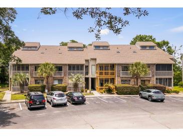 Inviting condo complex with brick facade, palm trees, and ample parking, perfect for coastal living at 1356 Glenns Bay Rd. # A202, Surfside Beach, SC 29575