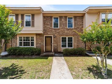 Charming townhome showcasing brick facade, complemented by lush greenery and inviting front entrance at 1409 Highway 15 # 4, Myrtle Beach, SC 29577