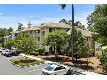 Well-maintained condo building with manicured landscaping, private balconies, and ample parking on a sunny day at 1551 Spinnaker Dr. # 5312, North Myrtle Beach, SC 29582
