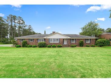 Charming brick home with a lush green lawn, manicured hedges, and classic shutters on a sunny day at 316 Oliver St., Marion, SC 29571