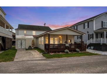 Charming home featuring a lovely front porch and a well-maintained yard, set against a colorful dusk sky at 6001-1453 S Kings Hwy., Myrtle Beach, SC 29575