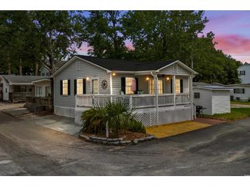 Charming beach cottage with a lovely front porch and landscaped yard at 6001-1808 S Kings Hwy., Myrtle Beach, SC 29575
