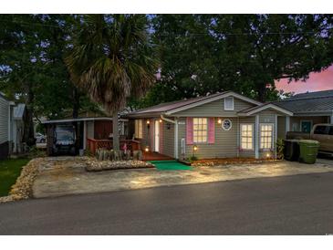 Charming home with a lush palm tree and pink shutters, offering a cozy coastal vibe at 6001-T3 S Kings Hwy., Myrtle Beach, SC 29575