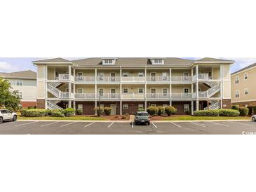 Three-story condo building showcasing balconies, staircases, brick accents, landscaping and parking area at 604 Heathrow Dr. # 1097, Myrtle Beach, SC 29579